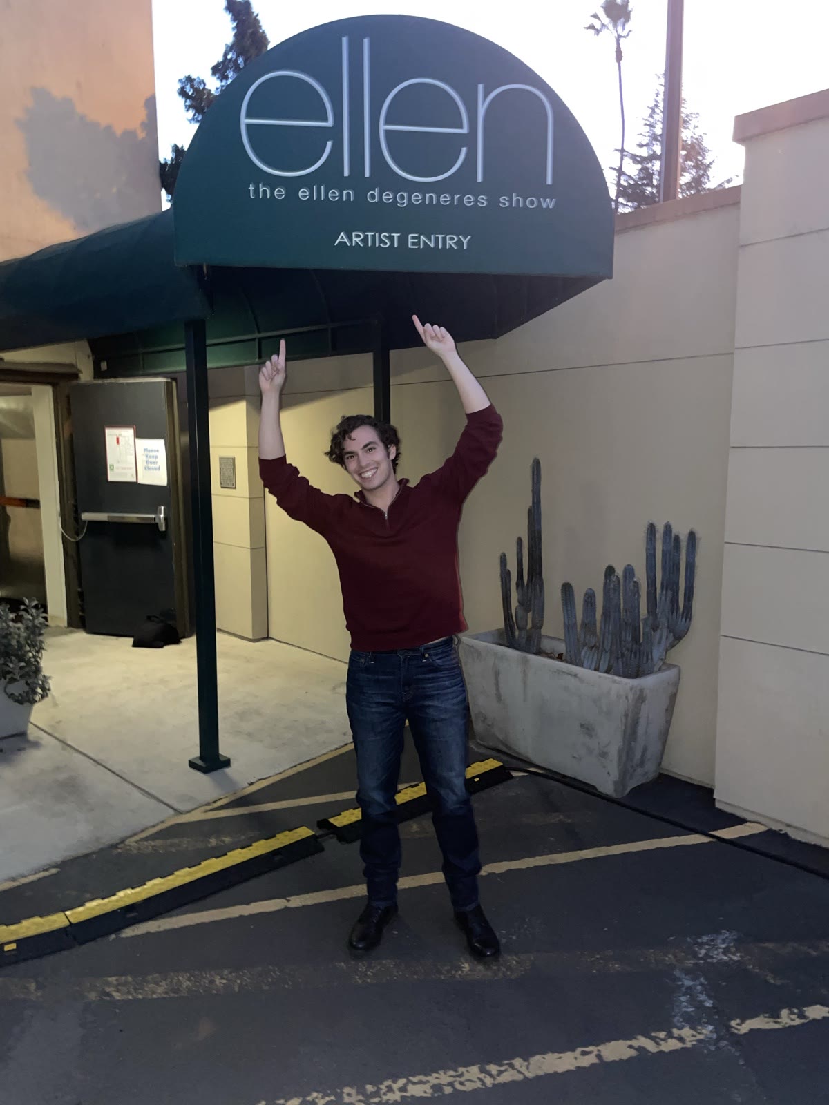 Neil Kelly outside The Ellen DeGeneres Show artist entry, arms raised in triumph