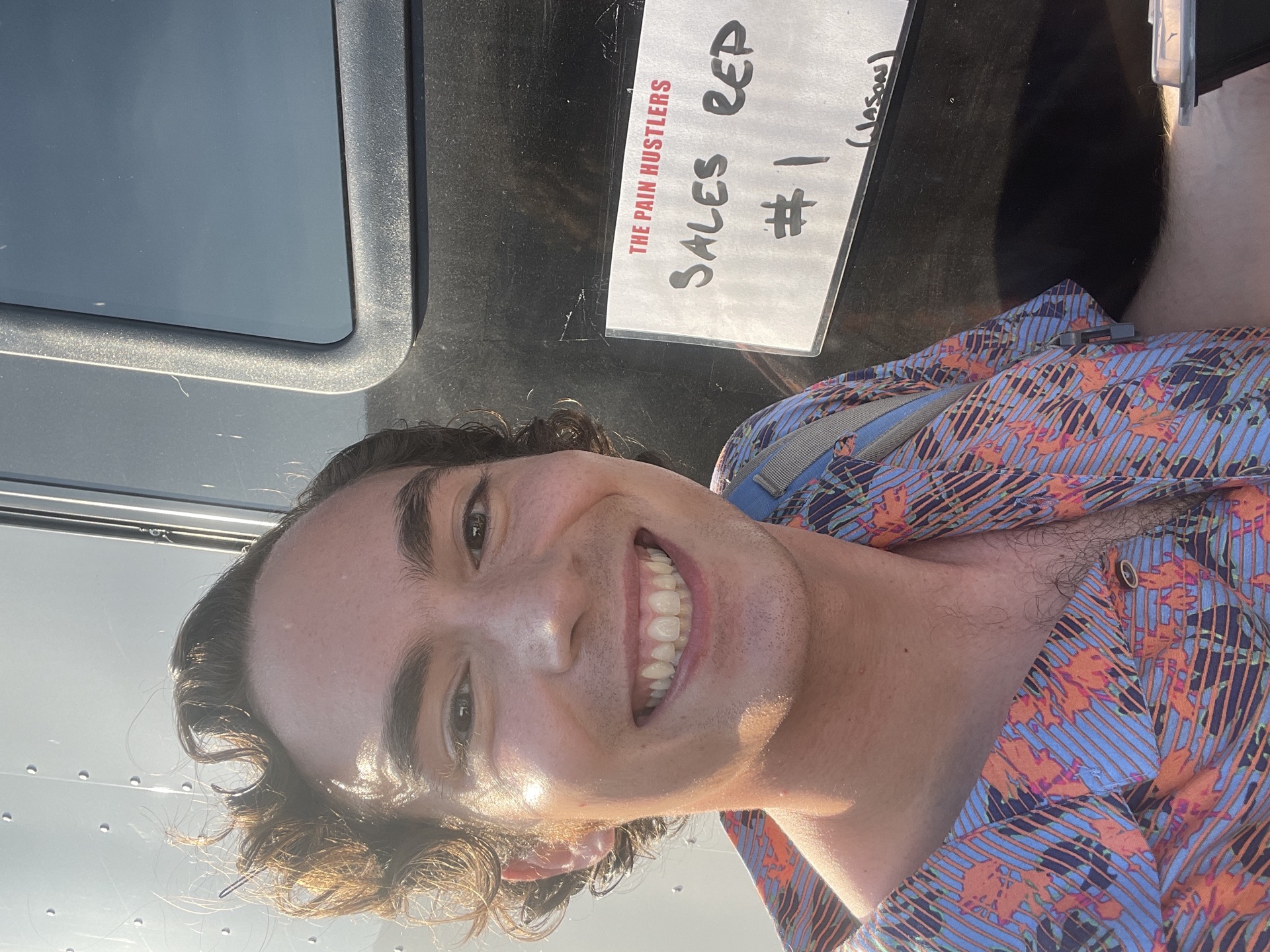 That sign on the trailer behind me said 'Sales Rep #1.' That's what booking from a secondary market actually looks like — not a glamour shot, just a name plate on a trailer in a parking lot in Atlanta.